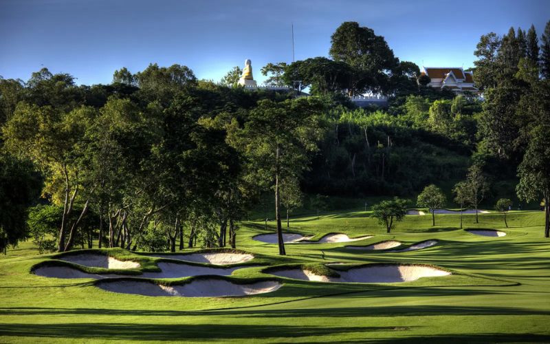 Beautiful view of Siam Country Club golf course featuring lush fairways, sand bunkers, and tree-lined hills in the background.